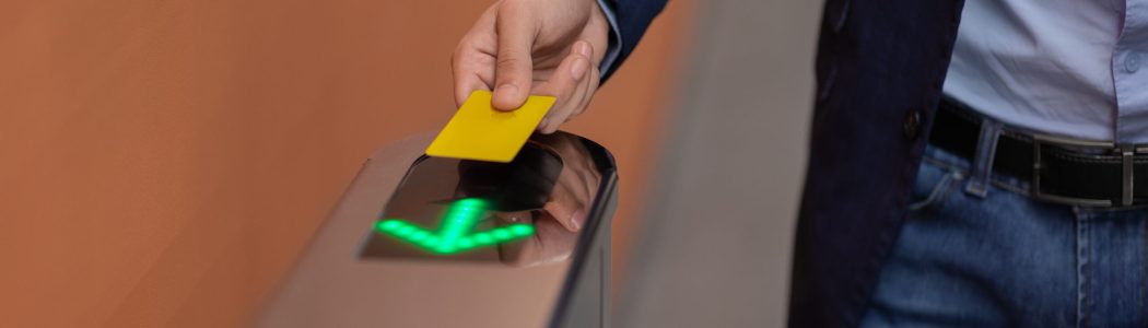 Unrecognizable man holding electronic entrance gate card, closeup Unrecognizable man in formal outfit holding Electronic entrance gate card, cropped of worker passing access building security system at office, panorama with copy space, closeup